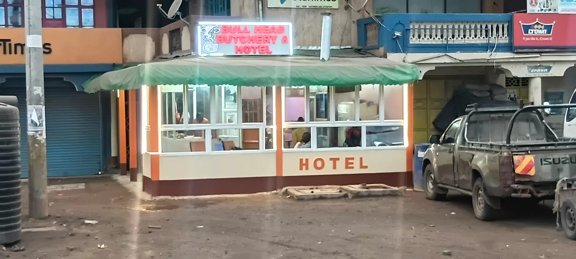 Bullhead Butchery & Hotel storefront lit up at dusk in Emali